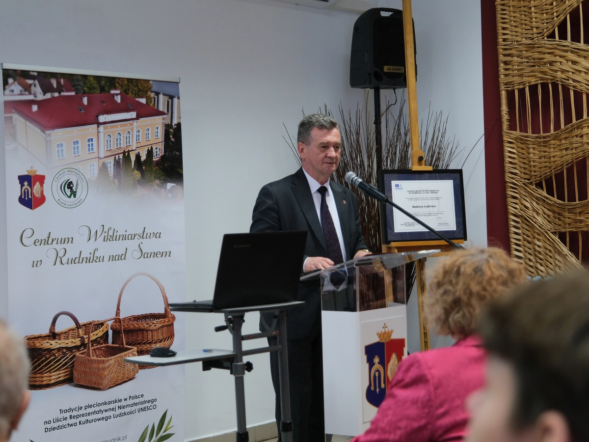 Mężczyzna przemawia przy mównicy podczas konferencji w Centrum Wikliniarstwa w Rudniku nad Sanem.